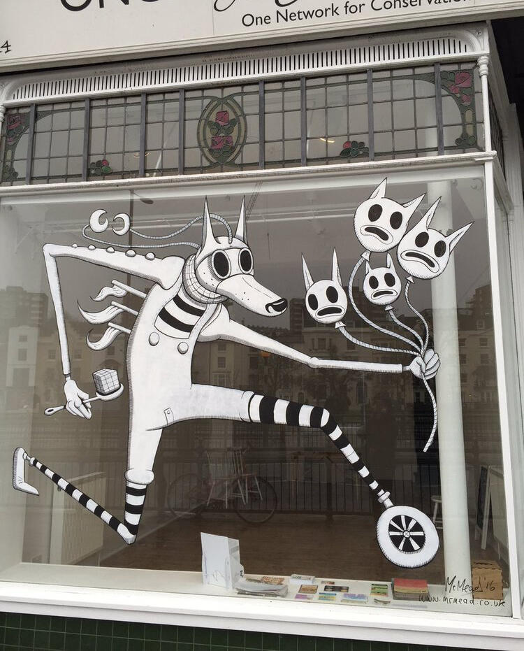Street art at ONCA Gallery: A whimsical black-and-white mural depicts a striped creature holding theatrical masks, evoking creativity and playfulness.